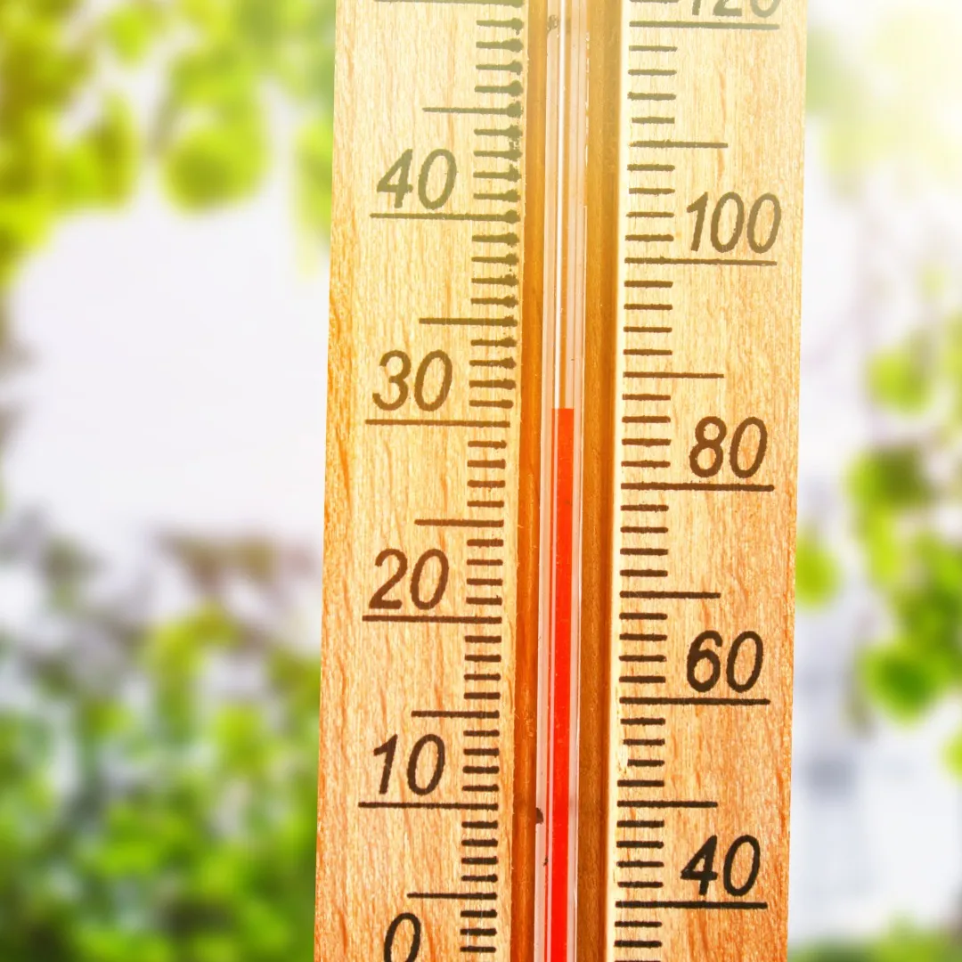 A wooden thermometer showing high temperatures