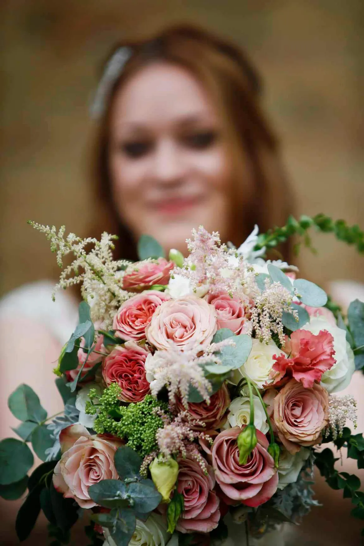 A bride holding a bouquet of pink and white flowers