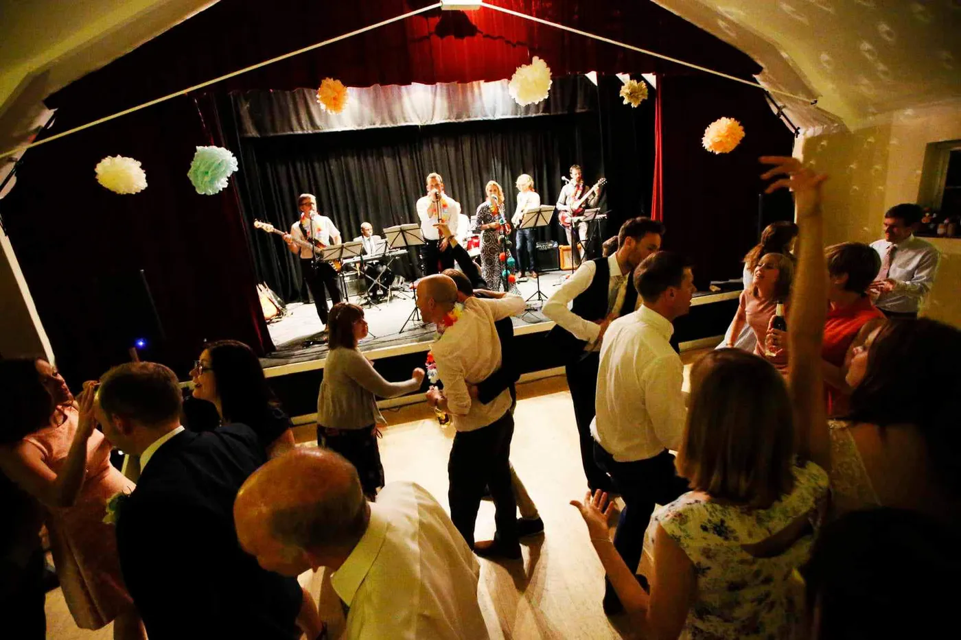 Guests dancing to a live band in a village hall