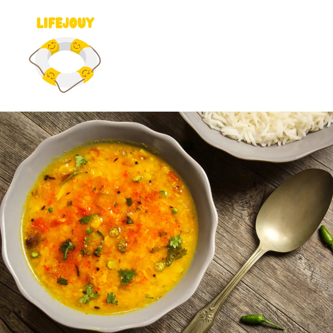 A bowl of yellow lentil dhal with rice and a spoon