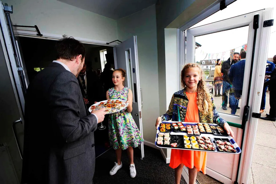 A girl carrying a tray of food at a wedding