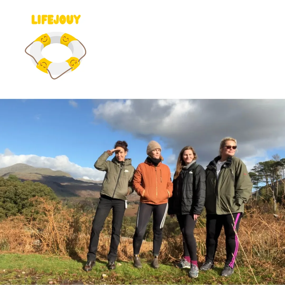 Four women in walking gear standing on a hillside