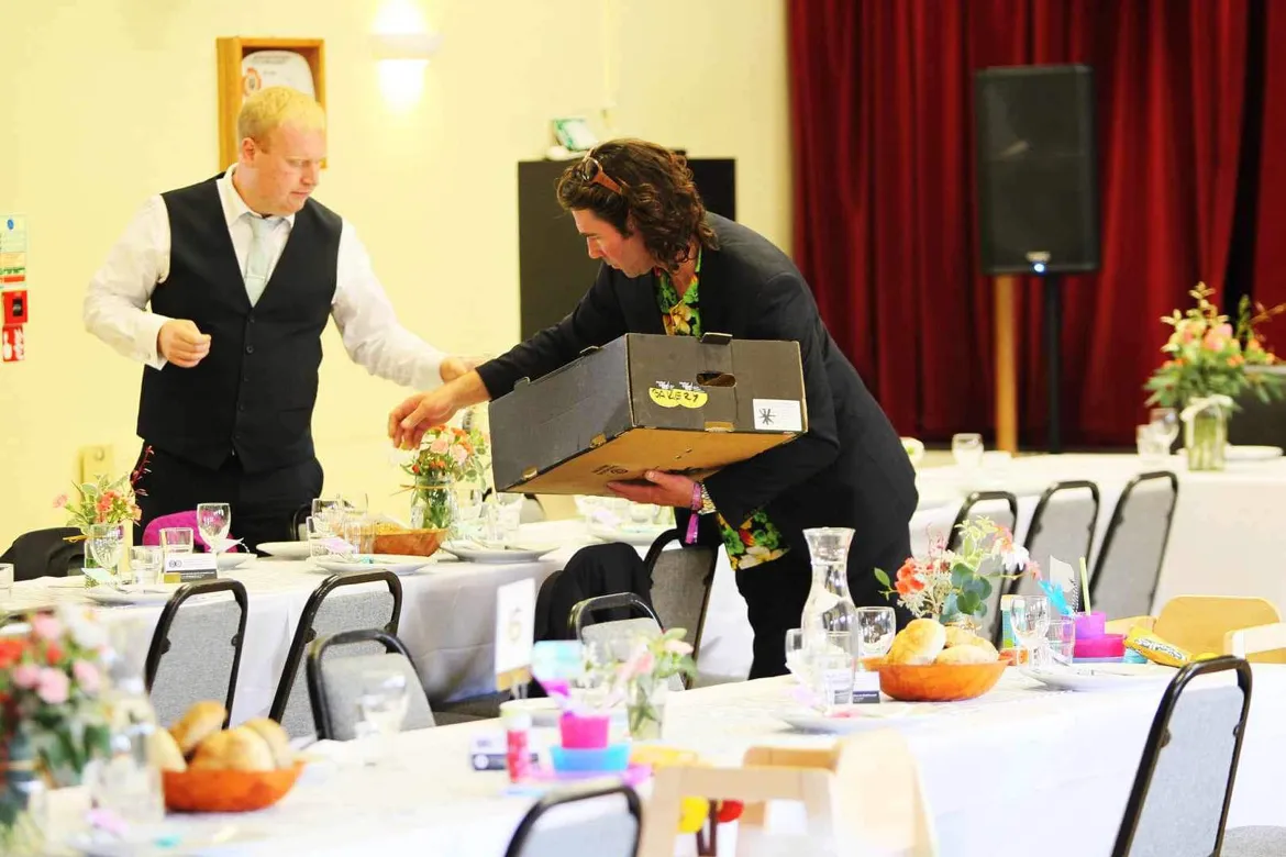 Setting out food on the tables in a village hall