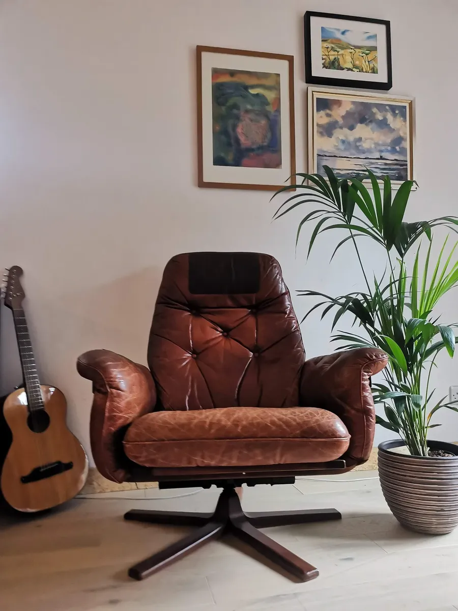 A second-hand leather armchair, guitar and plant in Anna's flat